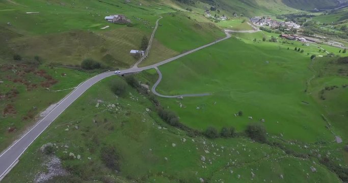 Aerial shot of SUV crusing along Furka Pass in summer in the Swiss Alps