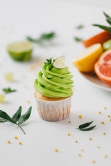 spring cupcake on a white background with flowers and fruits around.
