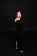 Elegance woman in black evening dress posed on studio isolated on black.