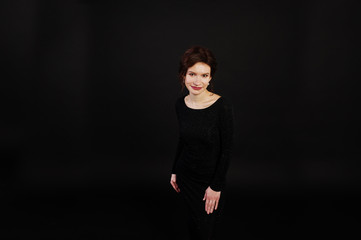 Elegance woman in black evening dress posed on studio isolated on black.