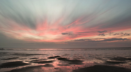 Fototapeta na wymiar Sunset with pink clouds over Wenduine beach at low tide