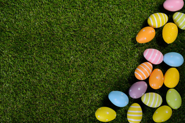 above top view of multi colored painted easter egg on springtime grown green grass