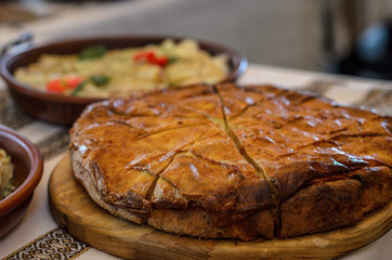 side view of a round closed cake with a filling cut into pieces and stands on a wooden stand