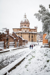 A lovely day of snow in Rome, Italy, 26th February 2018: a beautiful view of snowy Roman Forums and Church of the Saints Luca and Martina under the snow