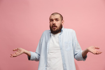 Let me think. Doubtful pensive man with thoughtful expression making choice against pink background