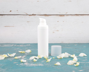 Kosmetikartikel und Rosenblätter auf verwittertem Hintergrund