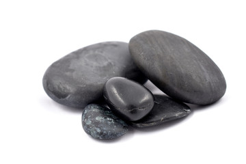 Fototapeta na wymiar Black massage stones stock images. Black stones on a white background. Massage stones for relaxation. Pile of black stones
