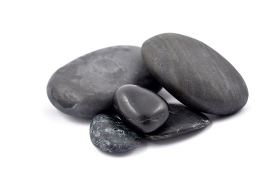 Black massage stones stock images. Black stones on a white background. Massage stones for relaxation. Pile of black stones