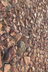 masonry of the old wall of rough cut red stone