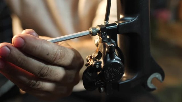 Close-uo of hands assembles a mountain bike in his workshop
