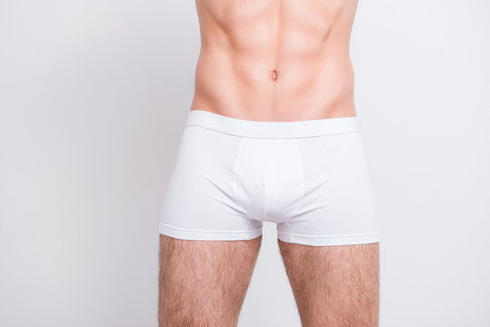 Men's health concept. Close up cropped photo of man's genitals, he is wearing white tight boxer-shorts isolated on white background
