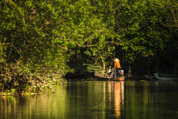 A woman rowing a boat with tourists aboard