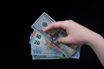 Hand holding American dollar  isolated on black background