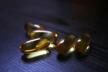 omega 3 fish oil capsules on wooden vintage table
