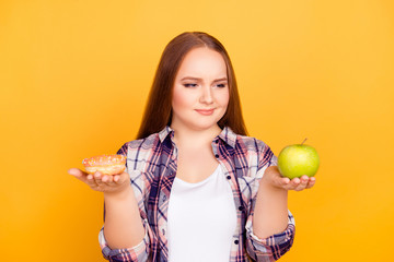 Young woman with a donut in one hand and an apple in other hand