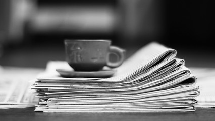 Naklejka premium Newspapers and cup of tea. Papers with news, concept for English breakfast. Morning in office with fresh media press, side view