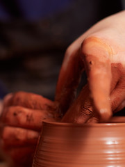 production process of pottery. Forming a clay teapot on a potter's wheel.