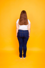 Fototapeta premium Rear view of young woman in tshirt and jeans