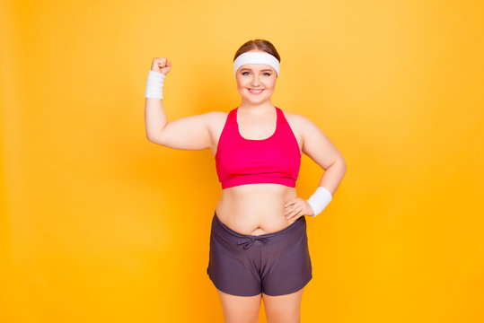 Young woman in exercise clothes flexes bicep