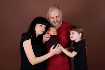 Family portrait: mother, father, daughter and newborn baby.