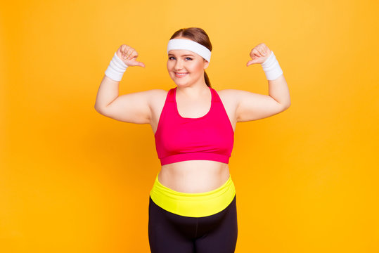 Young woman in exercise clothes flexes arms