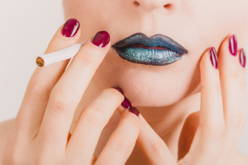 Naklejka premium Close up of woman face with cigarette and tinsel makeup