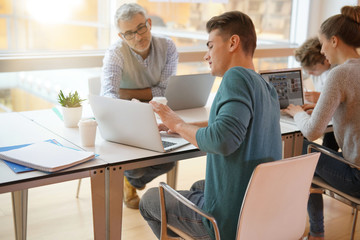 Teacher meeting around table with students