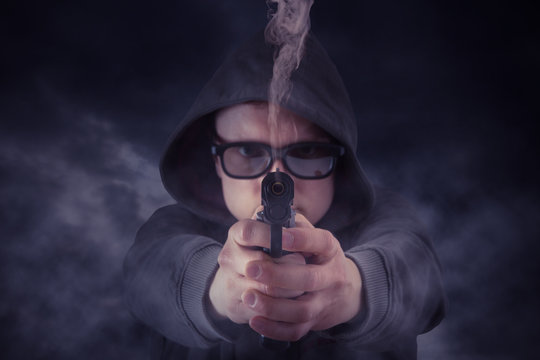 Mann im Kapuzenpullover zielt mit seiner Pistole