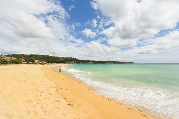 Unawatuna, Sri Lanka - A young woman walking at the beach of Unawatuna