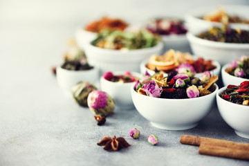 Assortment of dry tea in white bowls. Tea types backgound: green, black, floral, herbal, mint,...