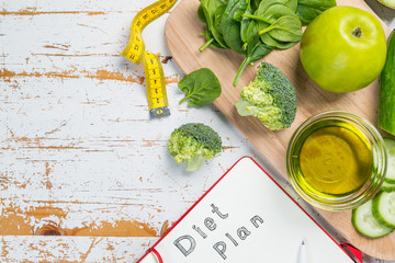 Diet plan concept - selection of green food and note pad