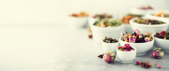 Assortment of dry tea in white bowls. Tea backgound: green, black, floral, herbal, mint, melissa,...