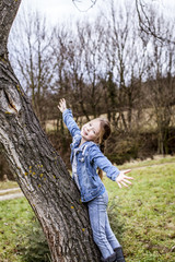 young beautiful girl is climbing on tree