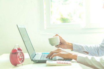 Fototapeta premium A business analyzing investment charts at workplace and using laptop and touch calculator.