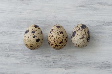 Three quail eggs on a white vintage background