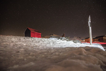 Overnight trip of mountains and wooden houses with the stars in the background.