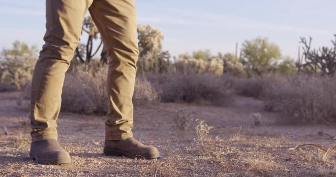 Cowboy stands in dueling position ready to shoot - close up on legs?
