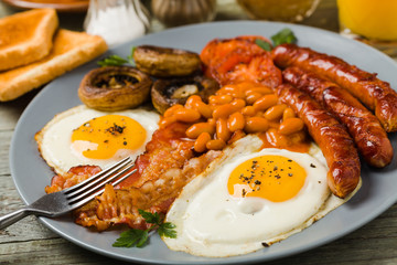 Full English breakfast, with sausage, mushrooms, beans and a fried egg.
