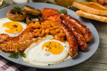 Full English breakfast, with sausage, mushrooms, beans and a fried egg.