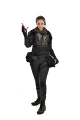 full length portrait of female  soldier wearing black  tactical armour with arms raised, isolated on white studio background.