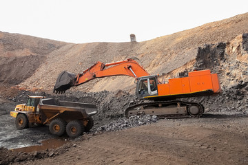 Excavator digging and loading ore rocks on a Manganese mine