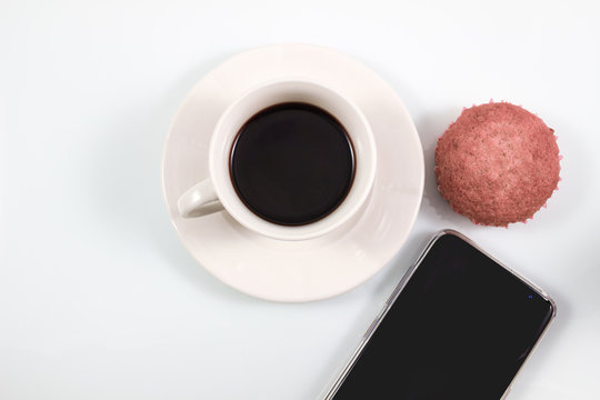 Top view, Espresso coffee in white cup with homemade brownie muffin cakes and smartphone isolated on white background, Coffee break in concept in soft tone vintage background.