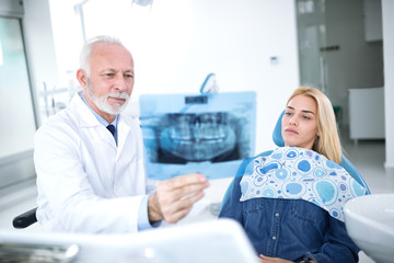 Dentist and patient are considering necessary treatments of teeth