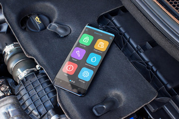 Mobile phone on a car engine with apps for diagnosing car problems.