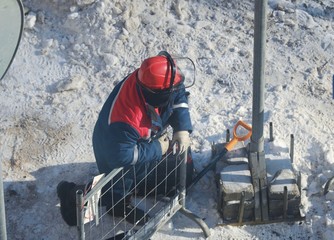 Working men in the form of standing around a sand pit