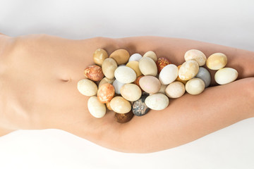 Nude woman body parts and  multicolored hand painted Easter eggs.