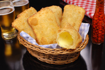 Brazilian typical pastry called pastel in black pub table background with one of cheese open
