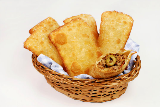 Fototapeta Brazilian typical pastry called pastel in white background with one of meat open