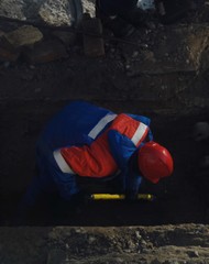 Working men in the form of standing around a sand pit 