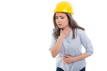 Female constructor holding her throat and stomach like hurting.